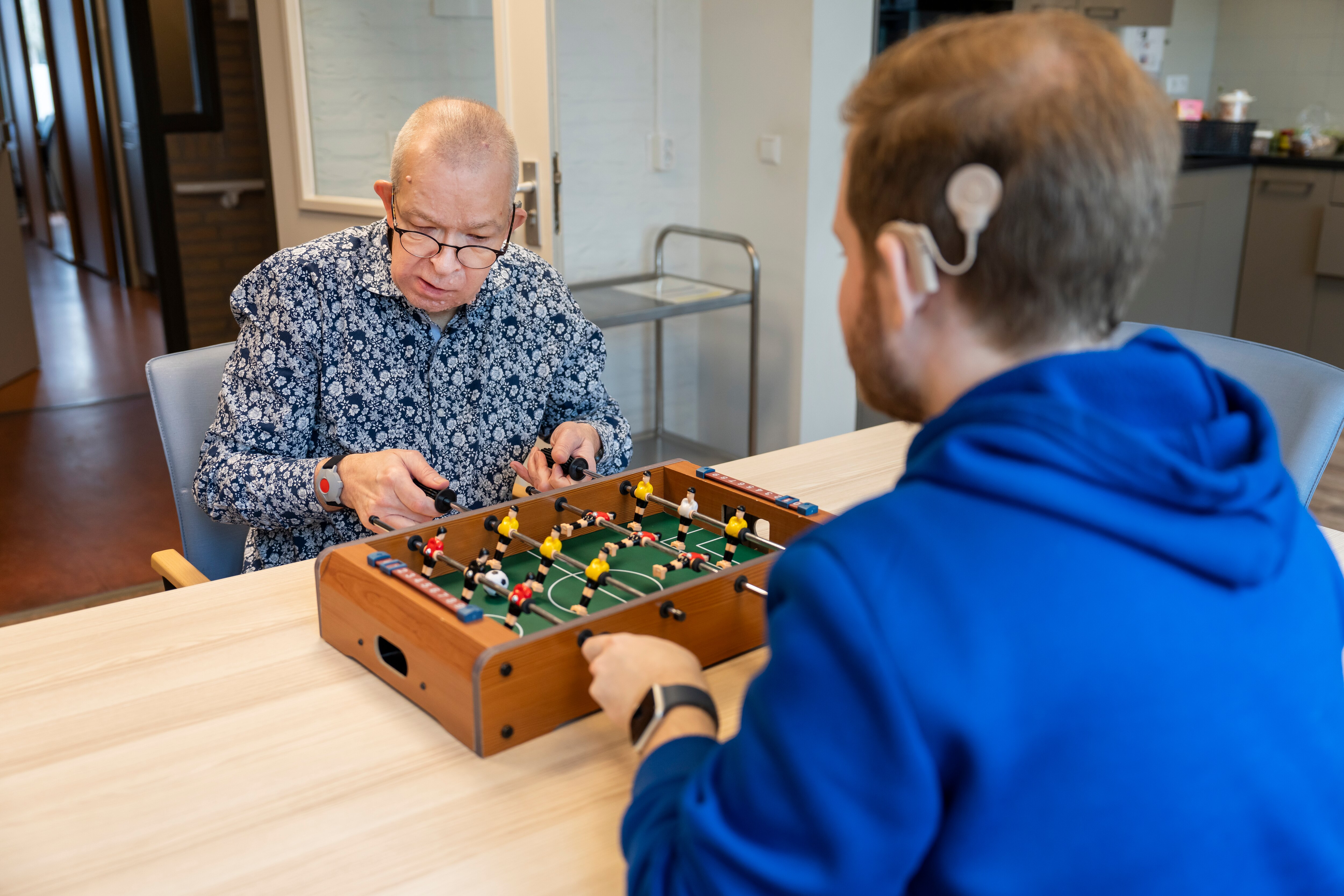 Medewerker en bewoner doen een spelletje