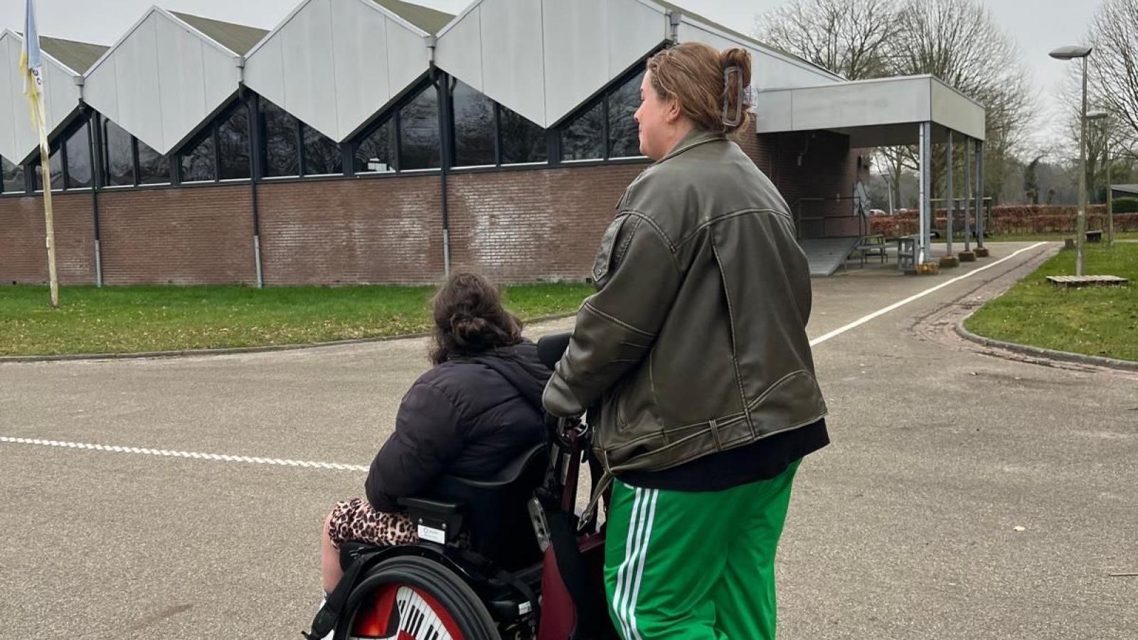 Stagiair Iris wandelt met bewoner in rolstoel
