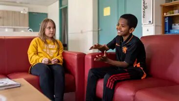Behandeling als een kind tegen nieuwe vragen aanloopt Twee kinderen op de bank bij de groepsbehandeling